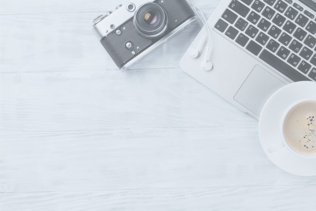 camera computer and coffee on desk